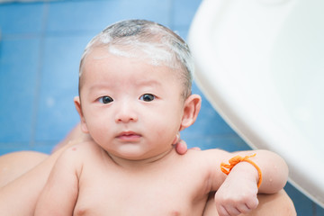 Mother give a bath her newborn baby, infant