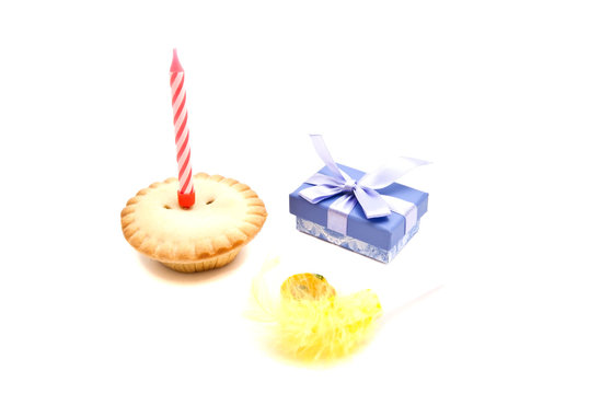 Cupcake with red birthday candle, whistle and gift