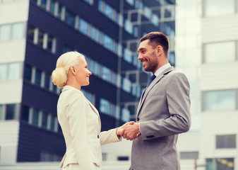 smiling businessmen standing over office building