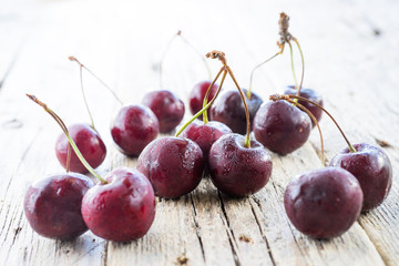  Cherries on wooden table with water drops