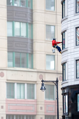 Window Washer on Tall Building – A man washes windows on a tall building.