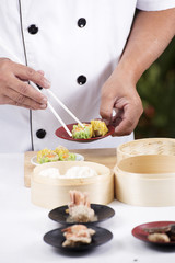 Obraz na płótnie Canvas Chef using chopsticks hold Chinese dumpling