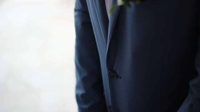 groom bottons his jacket