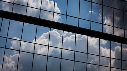 Office windows. Abstract full frame office windows of an anonymous city skyscraper reflecting the blue sky and clouds.
