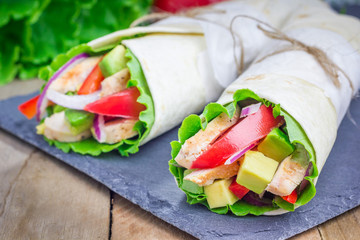 Tortilla wraps with roasted chicken fillet, avocado, tomato, onion and puprika