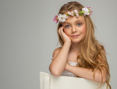 Fashion portrait of beautiful little girl with wreath