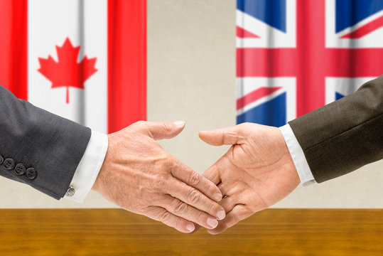 Vertreter Kanadas und Großbritanniens reichen sich die Hand