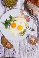 Beer and fried eggs with fresh parsley, a green peas and smoked