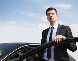 Young businessman near car