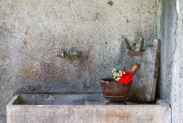 Old sink with mortar and geranium