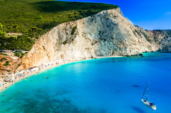 Porto Katsiki beach in Lefkada island, Greece. Beautiful view over the beach. The water is turquoise and there are tourists on the beach and a boat on the sea.