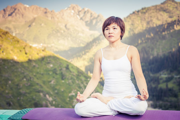 Fototapeta na wymiar Beautiful asian woman relaxing and meditating outdoor at mountain