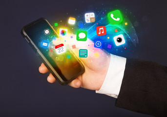 Hand holding smartphone with colorful app icons