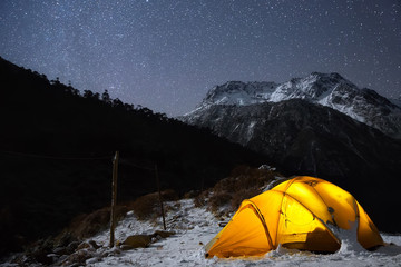 Camping under the light of billion stars. A starry night sky high in the mountains and a tent.  - 87673067