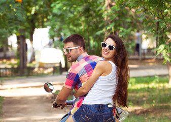 Riding a scooter together. Young couple riding a scooter