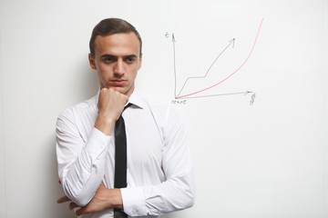 Portrait of thinking businessman standing near the whiteboard
