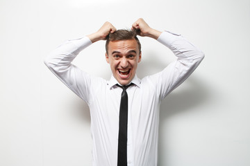 Angry businessman looking thoughtful while holding his head