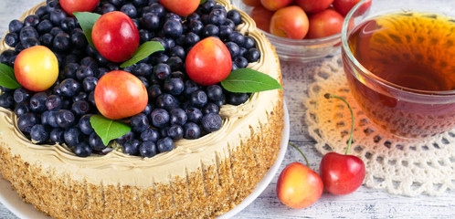 Celebratory cake with blueberries, sweet cherry, mint leaves and