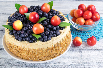 Obraz na płótnie Canvas Celebratory cake with blueberries, sweet cherry and mint leaves