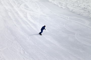 Ski slope and snowboarder at sun day