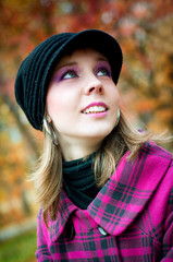 Smiling girl in pink coat in the fall