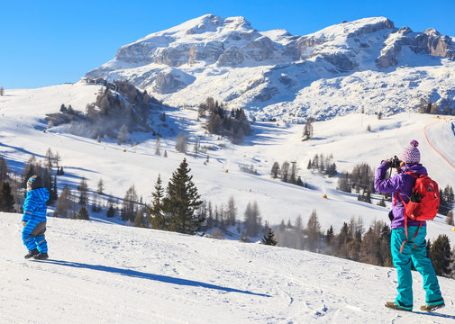 Mother child photographs on the slopes at the ski resort of Selv