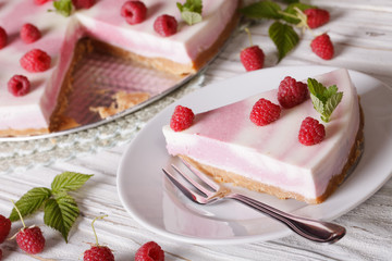Cutting piece delicate cheesecake with raspberries closeup. horizontal
