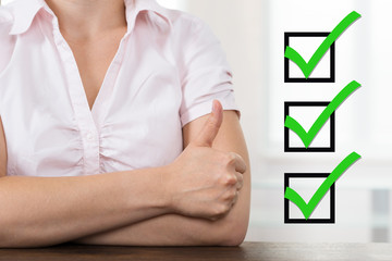 Businesswoman With Checklist Showing Thumb Up
