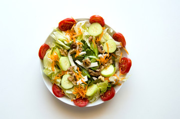 Italian salad with tomatoes, cucumbers, walnuts, carrots, lettuce and feta