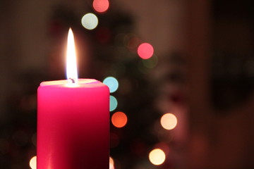 Brennende Kerzen und Weihnachtsbaum im Hintergrund an Weihnachten