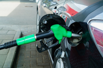 Car refueling on a petrol station. Focus on filling nozzles