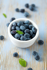 Honeysuckle berries in bowl on wooden surface