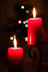 Brennende Kerzen und Weihnachtsbaum im Hintergrund an Weihnachten