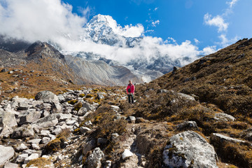 Woman backpacker standing in front Ama Dablam mountain.