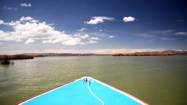 Blue boat passing through Lake Titicaca in Peru