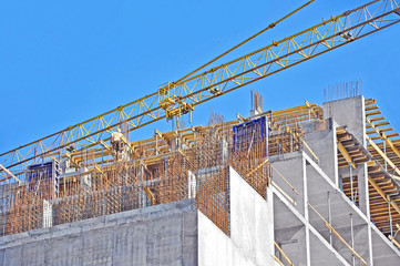 Fototapeta premium Crane and building construction site against blue sky