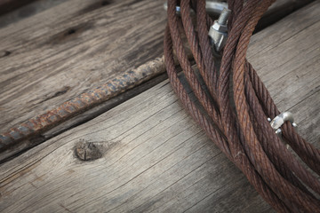 Obraz premium Abstract Rusty Iron Cable Laying on Old Wood Planks