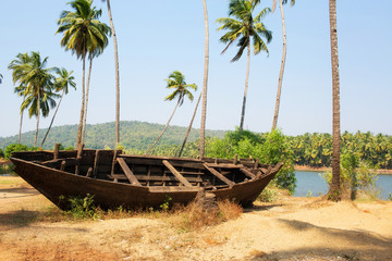 Fototapeta na wymiar Walpaper with old boat and palm trees.India