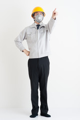 作業服を着た日本人男性,指を指している