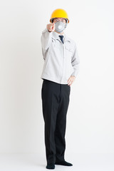 作業服の男性の全身写真,指を指している