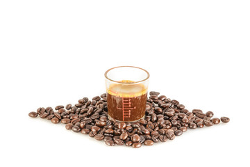 coffee in measuring glass and coffee beans on the white background