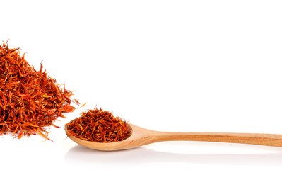 Safflower petals in a spoon on white background