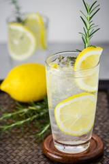 Lemonade with fresh lemon and rosemary in glass