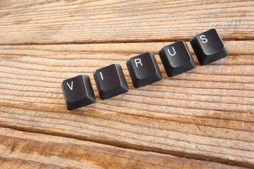 "VIRUS" wrote with keyboard keys on wooden background