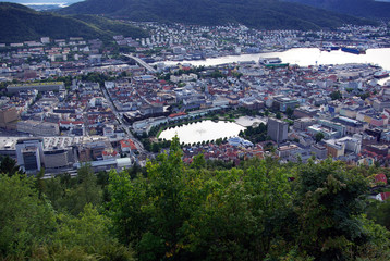 Norway. City of Bergen in the evening at sunset. Shooting a bird's eye view. View of the houses, streets, washing the fjord surrounding mountains. Picture 2500 * 1674.
