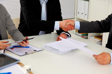 Business people handshake, sitting at the table