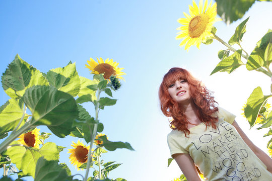 Красивая рыжая девушка в подсолнухах