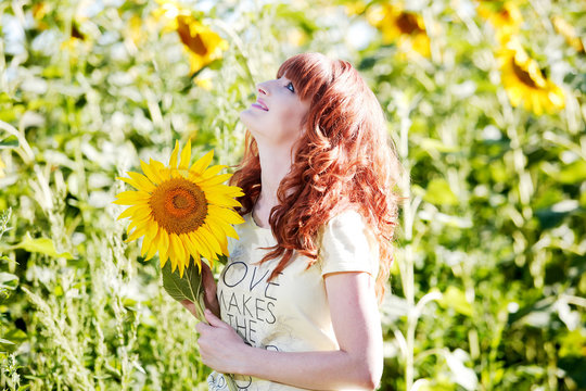Девушка в подсолнухах смотрит в небо