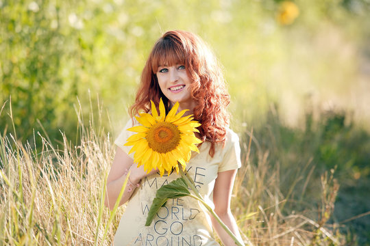 Красивая рыжая девушка в подсолнухах
