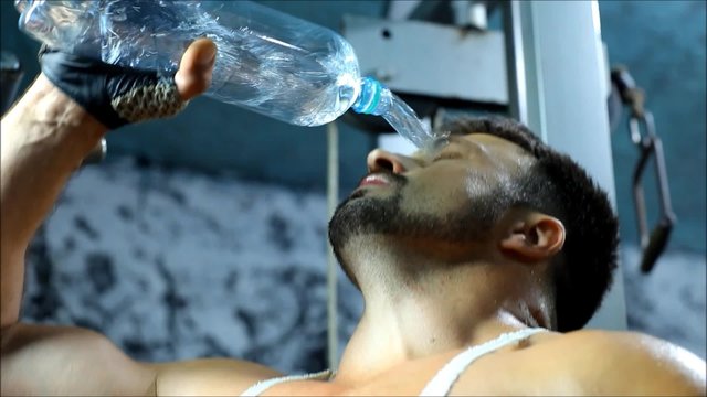  the man drink water in gym after sport in gym after sport 
